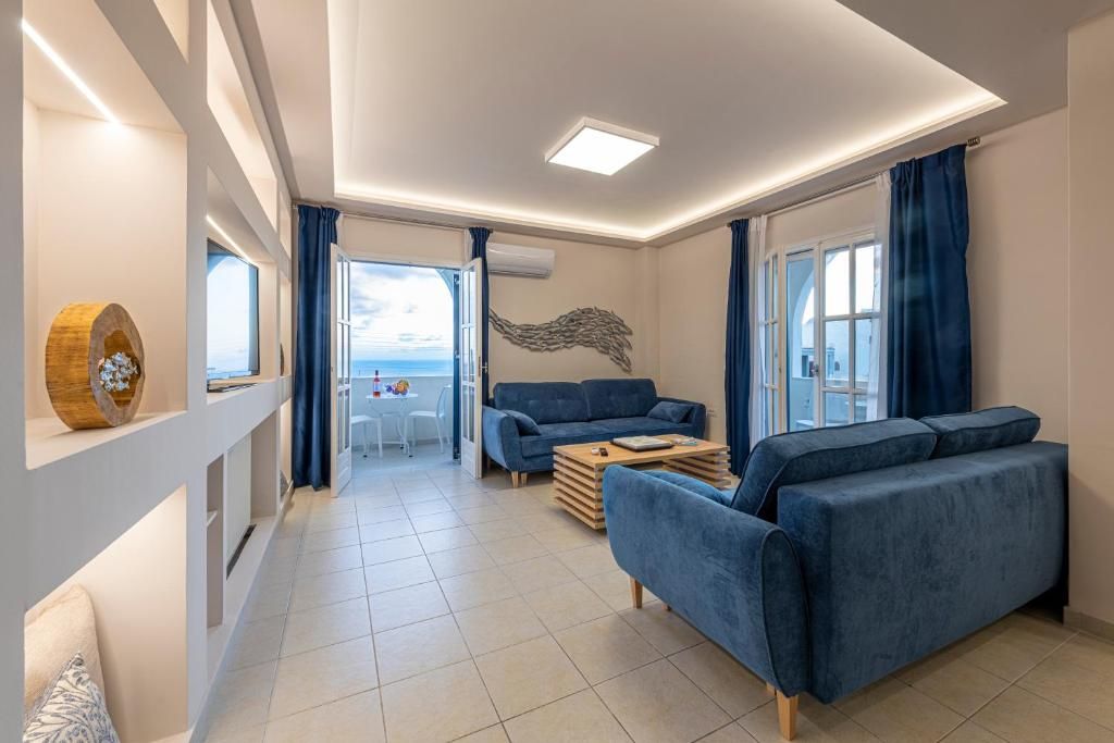 A modern living room with a sofa, a coffee table, and a view of the sea through large windows.