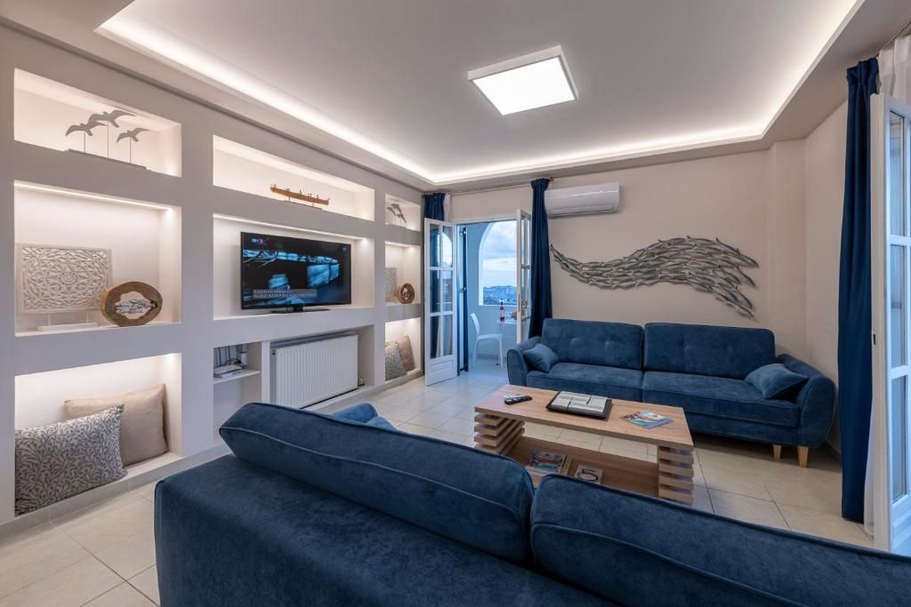 A modern living room with a large flat-screen TV, a blue sofa set, and a wooden coffee table.