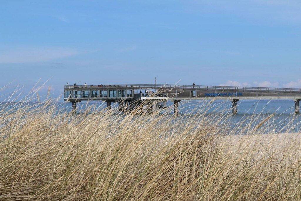 Une jetée s’avançant dans une étendue d’eau, sur laquelle se trouve un bâtiment.