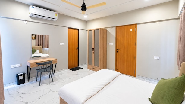 Un dormitorio moderno con cama, escritorio, silla, armario y ventilador de techo.