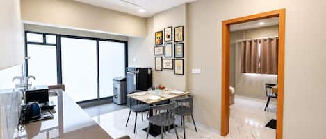 A modern kitchen with a dining area, large windows, and a view of the outdoors.