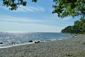 A pebbled beach with a clear sky and calm sea. - Holiday apartment with 1 bedroom (Fehmarn)