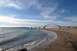 A beach with a bridge in the background. - Holiday apartment with 1 bedroom (Fehmarn)