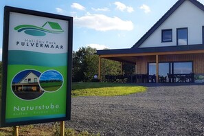 A sign for Holiday Park Pulvermaar with a modern building in the background. - Holiday apartment with 3 bedrooms (Gillenfeld)