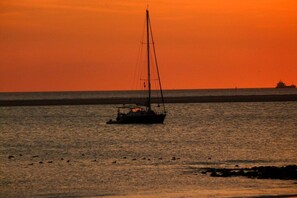 Ein Segelboot auf ruhigem Wasser bei Sonnenuntergang.