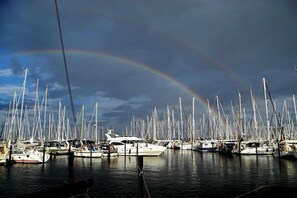 A marina with numerous boats docked, a clear sky, and a visible rainbow. - Holiday apartment with 1 bedroom (Heiligenhafen)