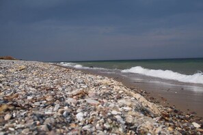 A pebble beach with waves, a clear sky, and a distant horizon. - Holiday home in Fehmarn with 2 bedrooms (Fehmarn OT Bannesdorf)