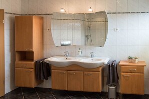 Ein Badezimmer mit zwei Waschbecken, einem Spiegel und Holzschränken.