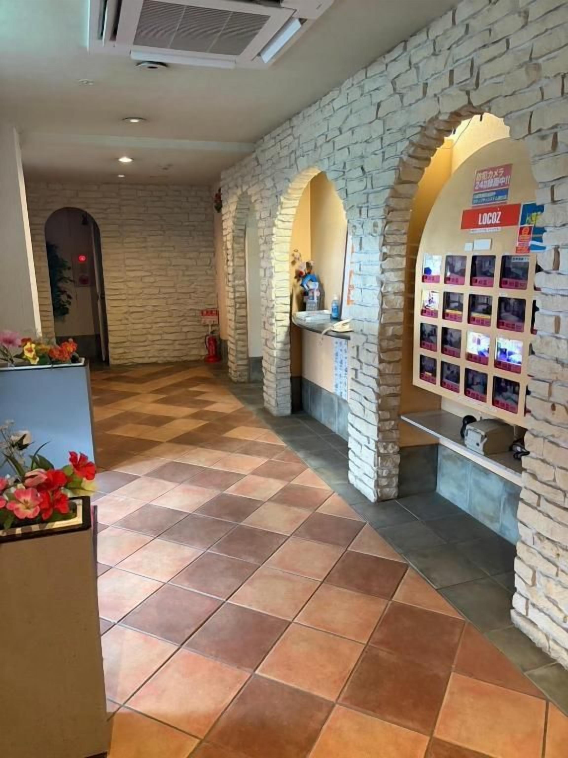 A lobby with a check-in counter, a reception desk, and a display of photos.
