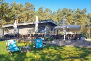 A building with outdoor seating and a covered patio area. - Trailer in Jabel with swimming pool (Jabel)