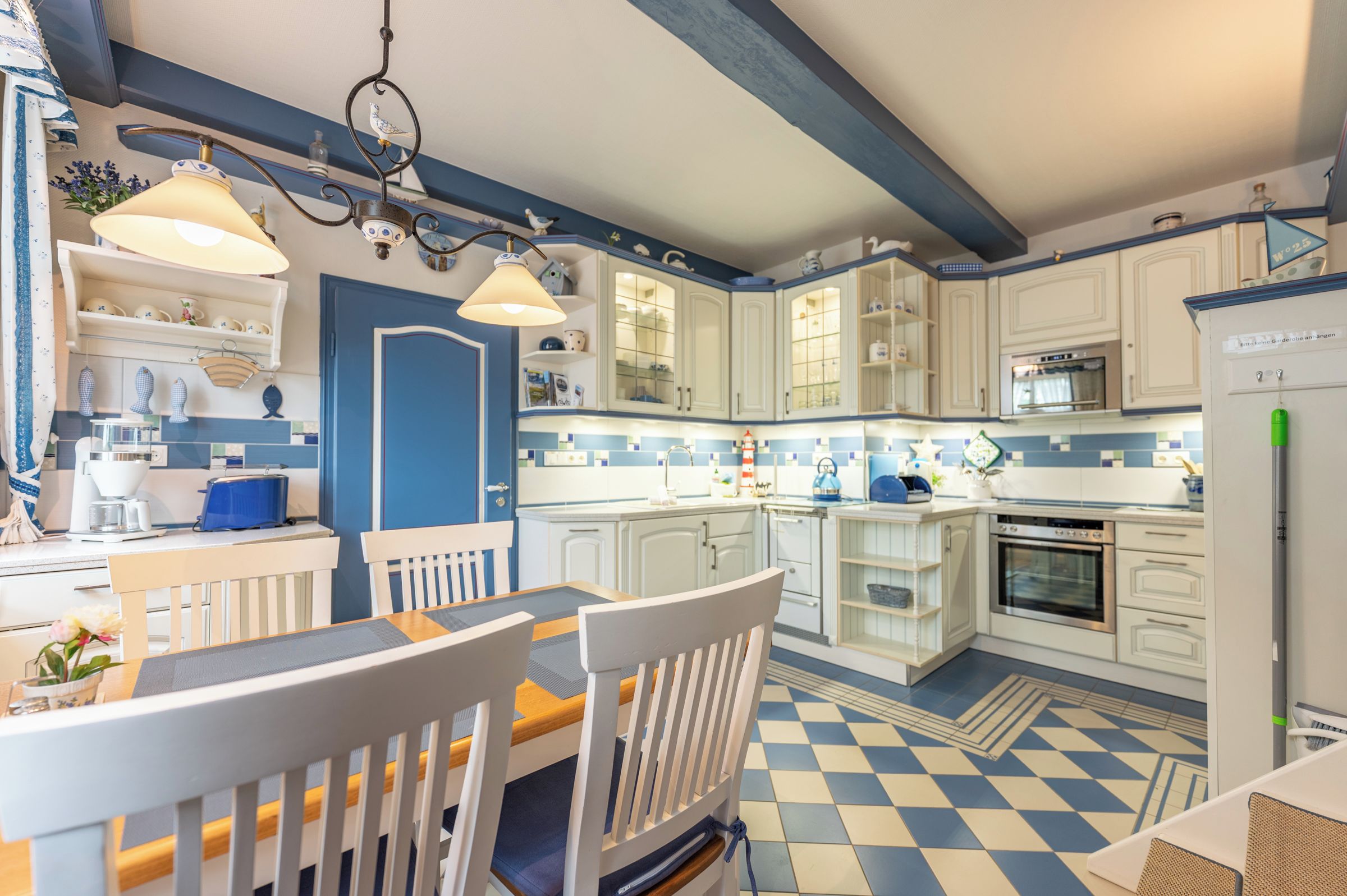 A kitchen with white cabinets, a blue door, and a checkered floor pattern.