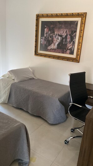 Une chambre avec deux lits, un bureau et une chaise.