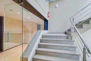 A staircase with a metal handrail and glass walls on one side. - Townhouse Oak Sapphire Star (Indore)