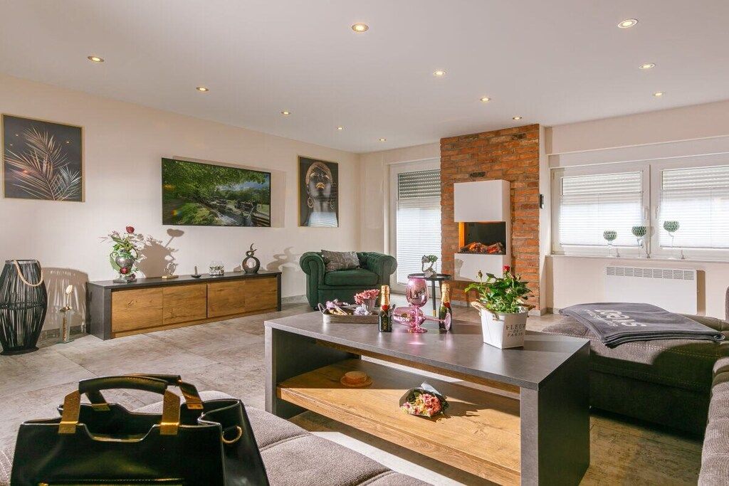 Una sala de estar moderna con un sofá, una mesa de centro y una chimenea.