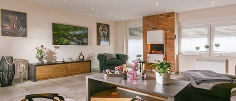 A modern living room with a sofa, a coffee table, and a fireplace.