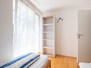 Ein Schlafzimmer mit einem Bett, einem Kleiderschrank und einer Tür.