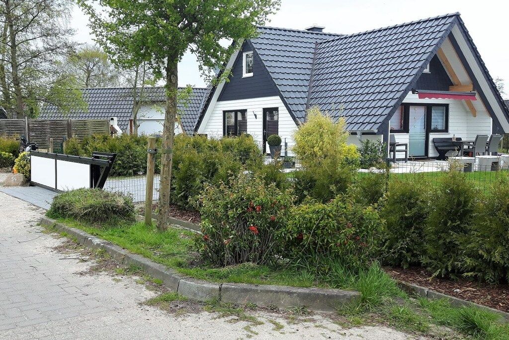 A residential property with a sloped roof, a visible front door, and a small patio area with outdoor furniture.