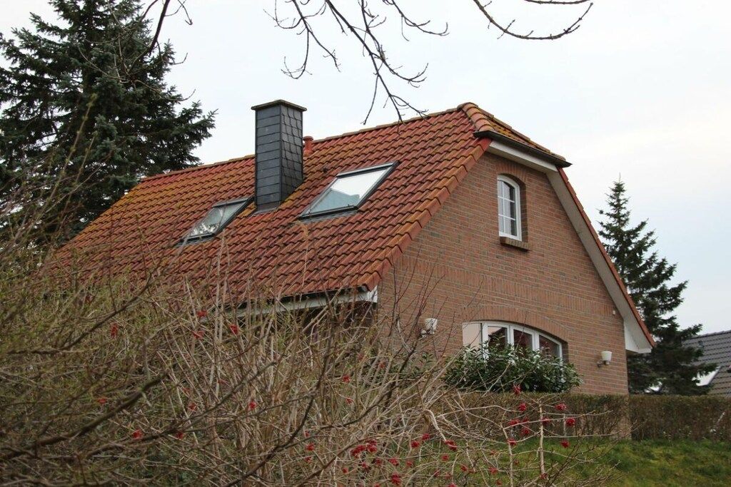 A house with a sloped roof, a chimney, and a window.