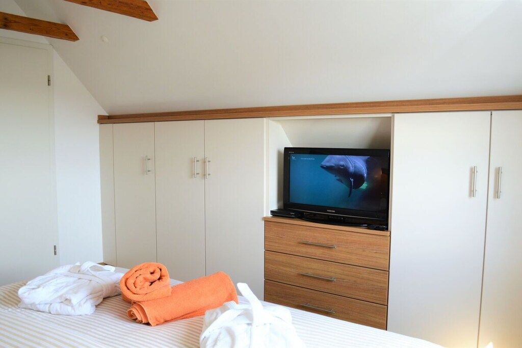 Ein Hotelzimmer mit einem Bett, einem Fernseher und einem Kleiderschrank.