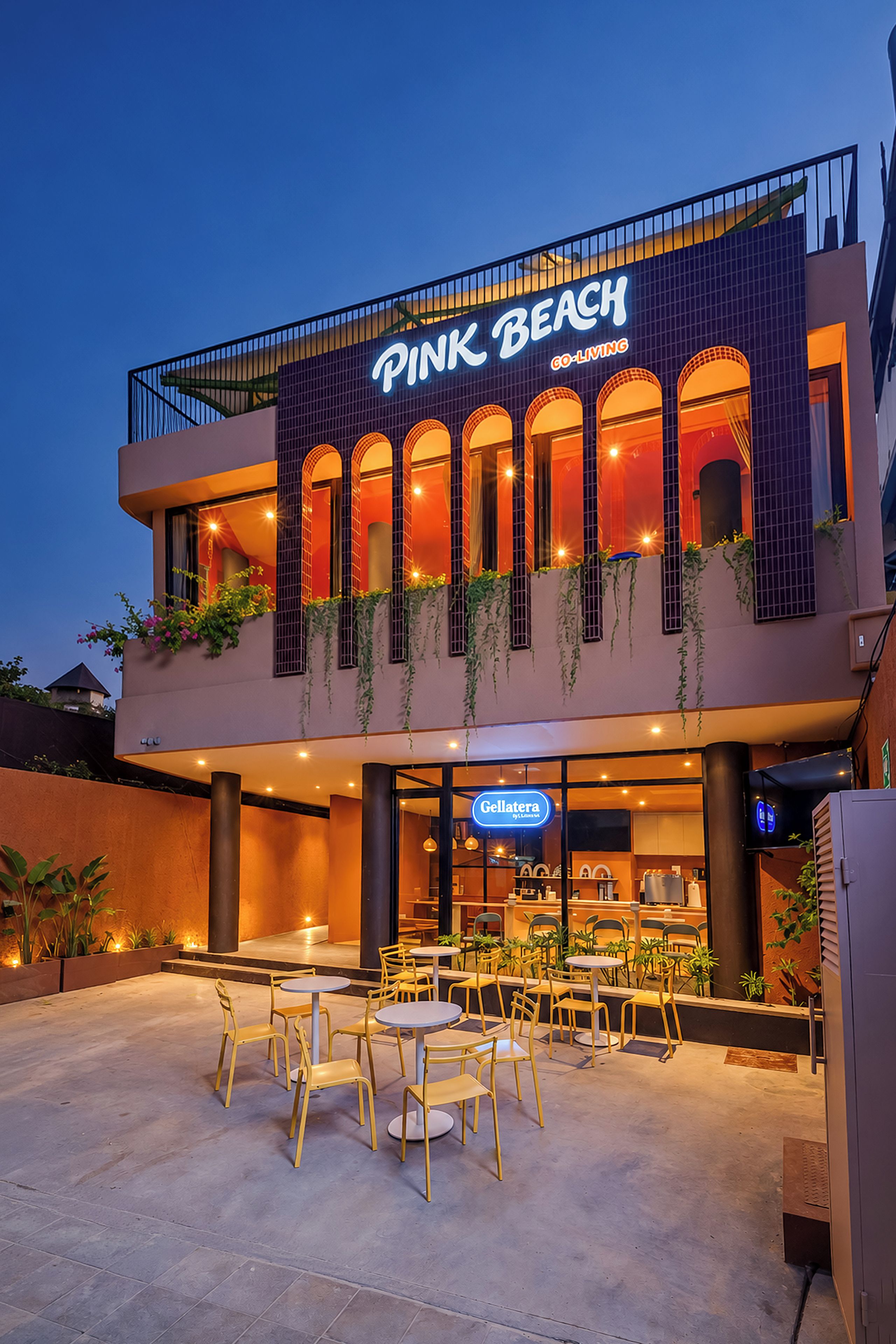 A Pink Beach hotel with outdoor seating and a visible restaurant named 'Gellatera.'