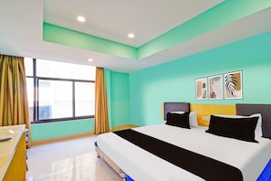 A hotel room with a bed, a desk, and a window with curtains. - Townhouse Oak SR Nagar Metro Station (Hyderabad)