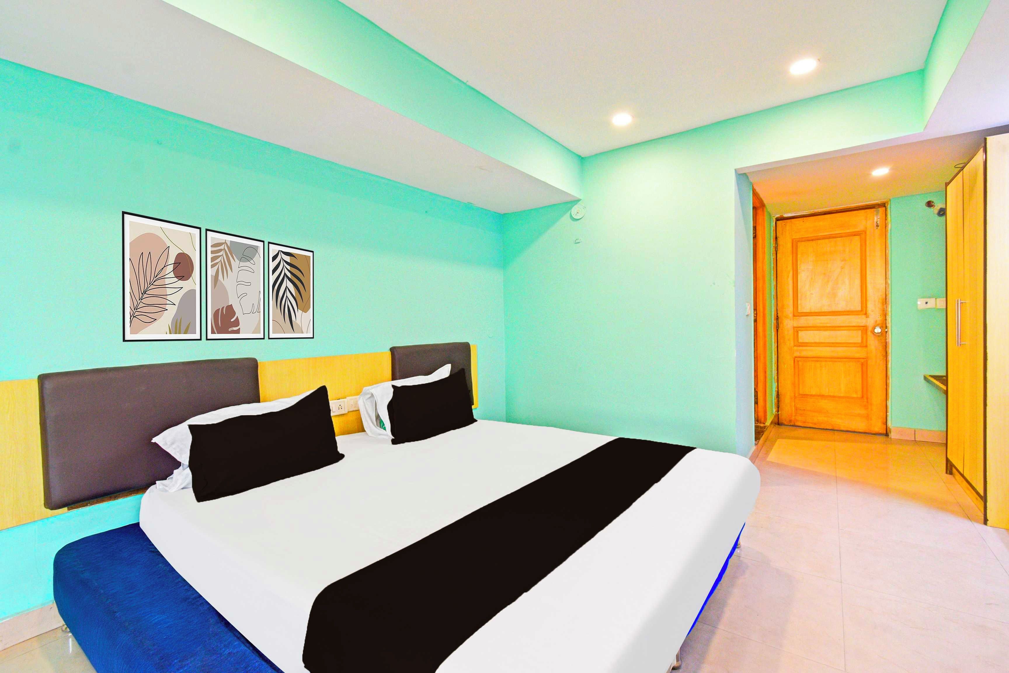 Un dormitorio con cama, cabecera, mesita de noche y lámpara de pared.