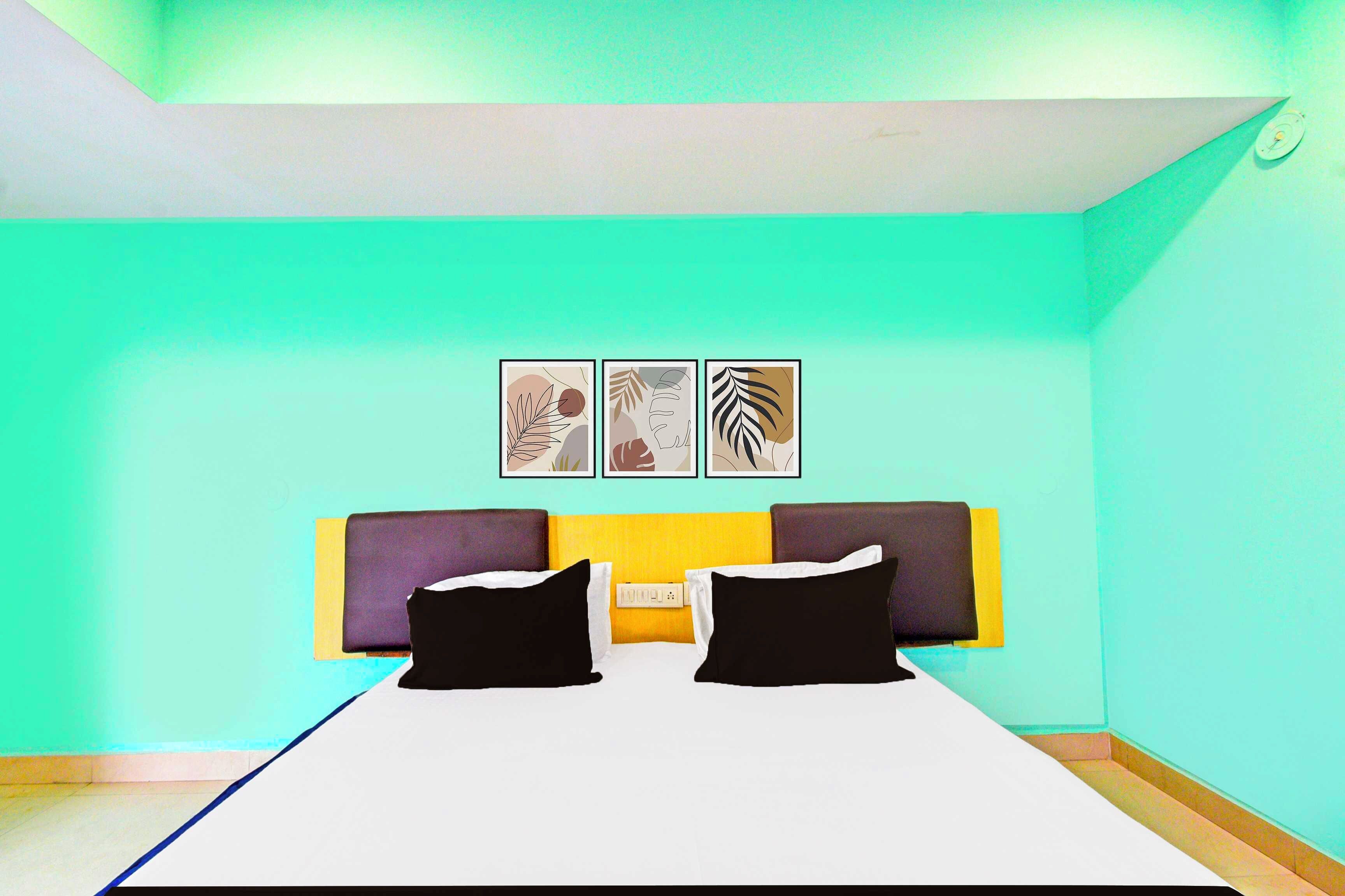 A modern bedroom with a bed, two pillows, and three wall-mounted artworks.