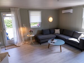 A modern living room with a grey sectional sofa, a round coffee table, and a small side table with a vase of flowers. - "Aapeli" - 3.9km from the sea by Interhome (Eskebjerg)