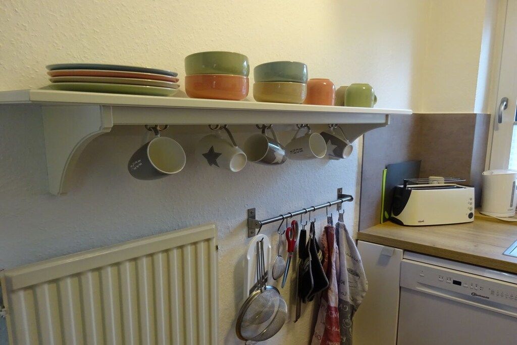 A kitchen with a white countertop, a toaster, and a dish rack.