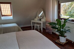 A bedroom with a bed, a desk with a mirror, and a potted plant. - Holiday apartment with 1 bedroom (Bremen)