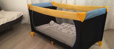 A small, enclosed play area with a soft, patterned floor and a mesh side.