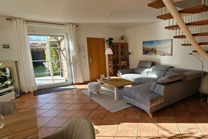 Ein Wohnzimmer mit einer Couch, einem Couchtisch und einer Treppe.