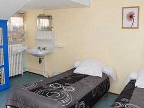 A hotel room with two beds, a bathroom with a sink and mirror, and a radiator. - Holiday Home 'Chambre Pour 3 Au RDChaussée' with Mountain View, Shared Terrace and Wi-Fi (Font-Romeu-Odeillo-Via)