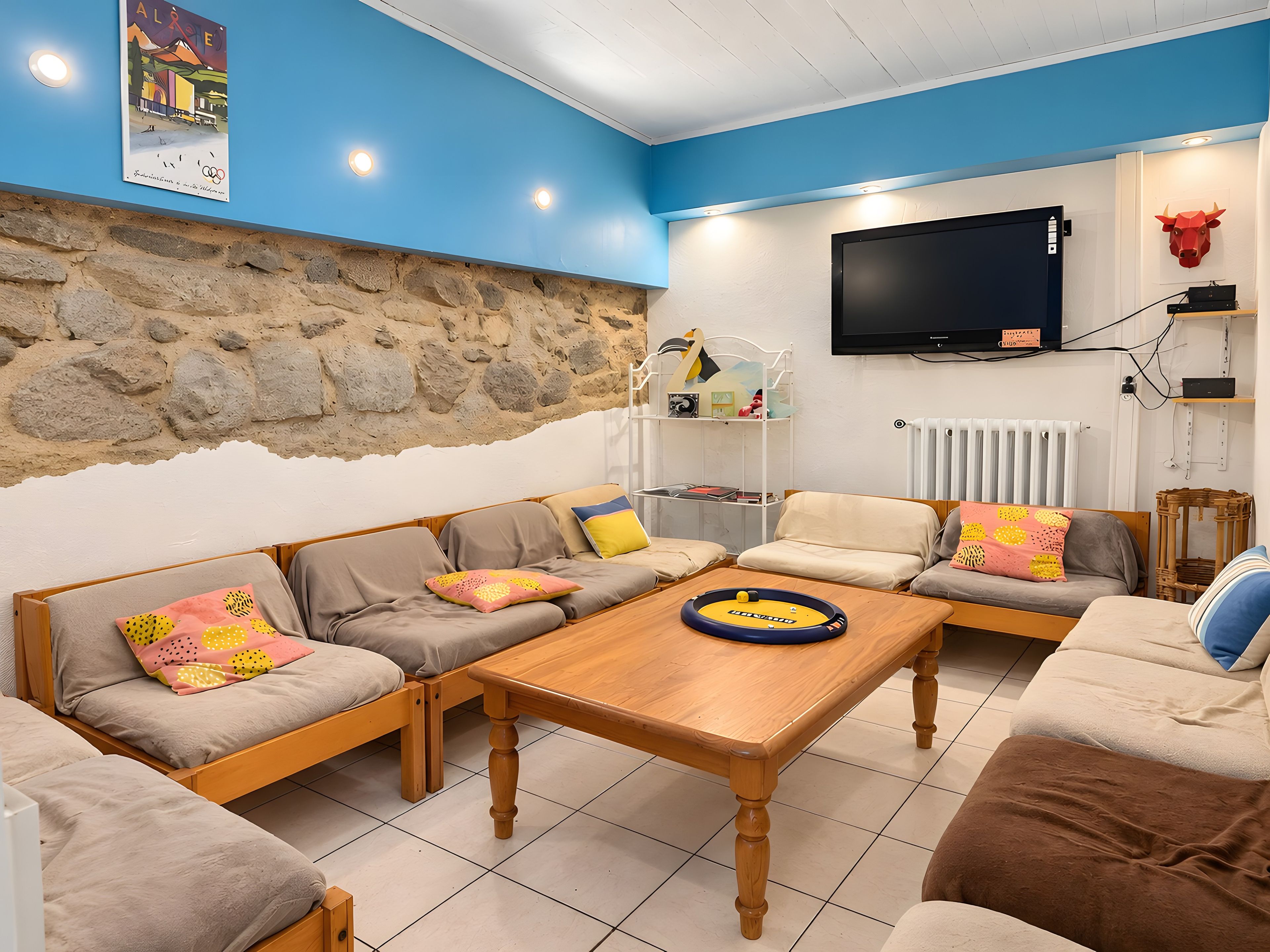 A living room with a stone wall, a television, and a wooden coffee table.