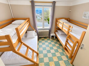A room with bunk beds, a window with curtains, a radiator, and a checkered floor. - Holiday Home 'Chambre Pour 4 Au RDChaussée' with Mountain View, Shared Terrace and Wi-Fi (Font-Romeu-Odeillo-Via)