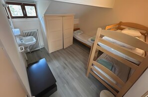 A compact room with a bunk bed, a small desk, a radiator, and a window. - Holiday Home 'Chambre Pour 7 Au RDJardin' with Mountain View, Shared Terrace and Wi-Fi (Font-Romeu-Odeillo-Via)