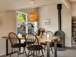 A dining area with a wooden table, chairs, a hanging light fixture, and a fireplace. - "Verner" - 1.6km from the sea by Interhome (Blokhus)