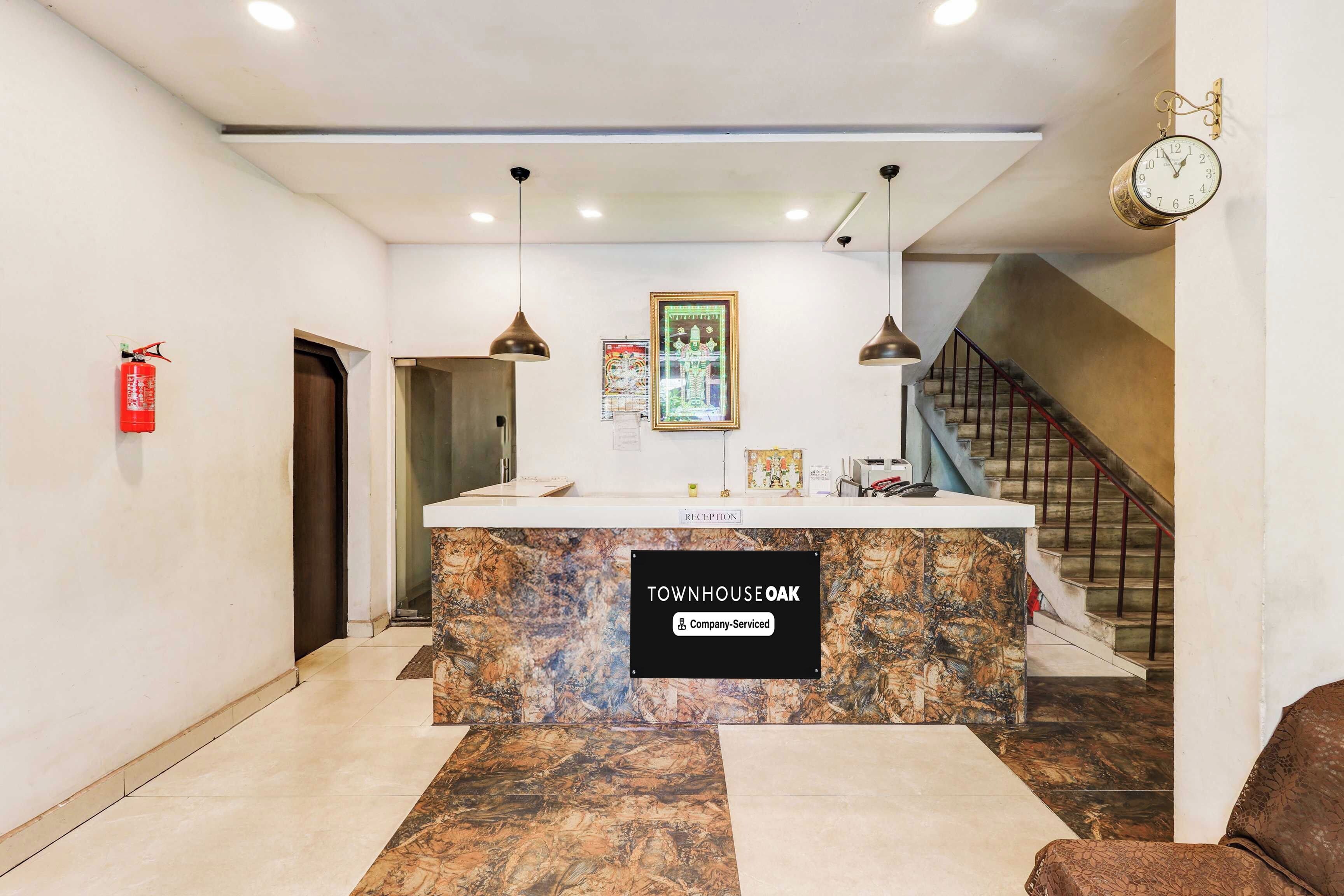 A reception desk with a marble top, a clock, and a framed picture on the wall.