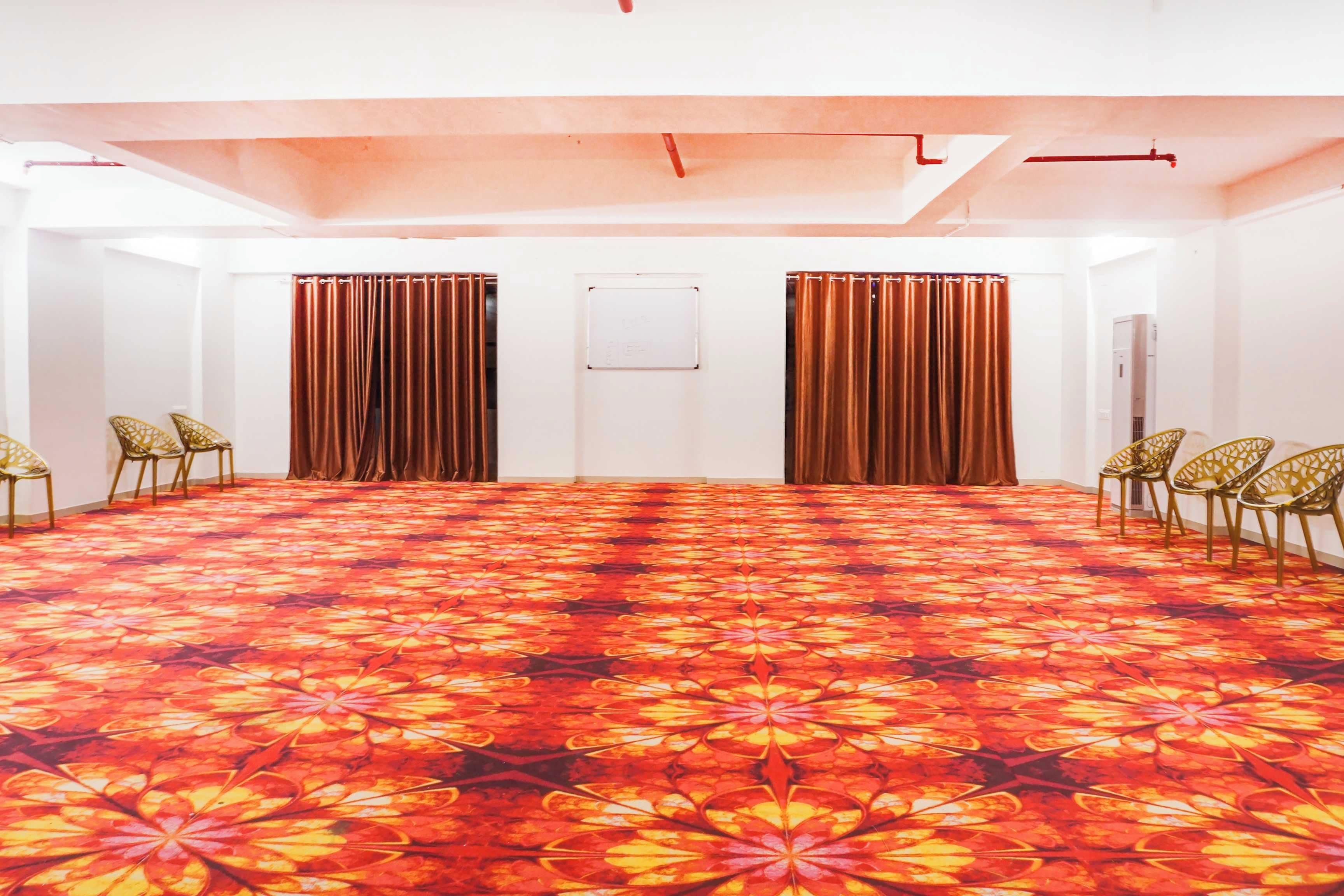 Una sala conferenze con tappeto a motivi, pareti bianche e tende.