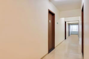 Un pasillo limpio y bien iluminado con una puerta de madera y un cartel que indica la habitación 301.
