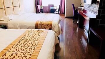 Habitación de hotel con dos camas, un escritorio, una silla y vistas al exterior.