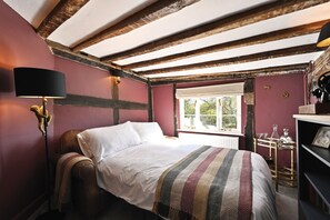 A room with a bed, a lamp, a window, and a shelf with items. - Blackham Farm  -  a holiday let sleeping 14 guests  in 6 bedrooms (Tunbridge Wells)