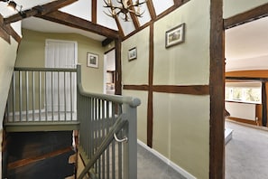 A staircase with a wooden handrail and a door at the top. - Blackham Farm  -  a holiday let sleeping 14 guests  in 6 bedrooms (Tunbridge Wells)