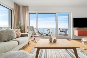 A modern living room with a sofa, armchair, coffee table, and a flat-screen TV. - Apartment in Olpenitz with swimming pool (Olpenitz)