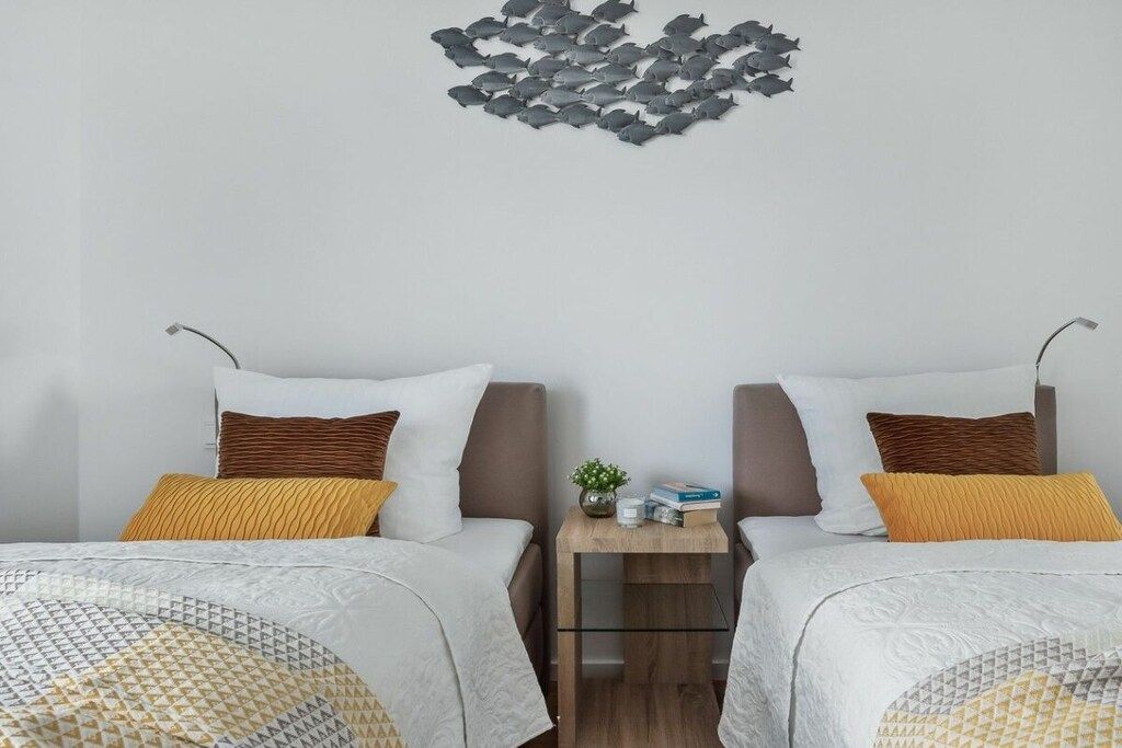 A hotel room with two beds, a bedside table, and a wall decoration.