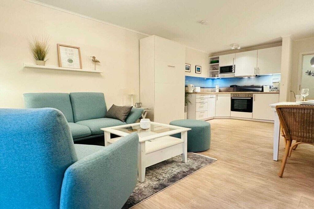A modern living room with a sofa, coffee table, and a dining area with a chair.