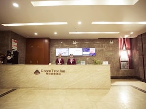 A reception desk with a logo, two staff members, and informational posters. - Greentree Inn Xian Yanta District Dayanta Furongyuan Hotel (Xi'an)