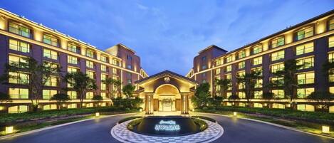 A hotel with a central courtyard, multiple floors, and a symmetrical facade.
