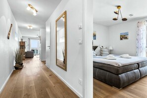 Une chambre d’hôtel moderne avec un grand lit, un miroir et une vue sur l’extérieur.