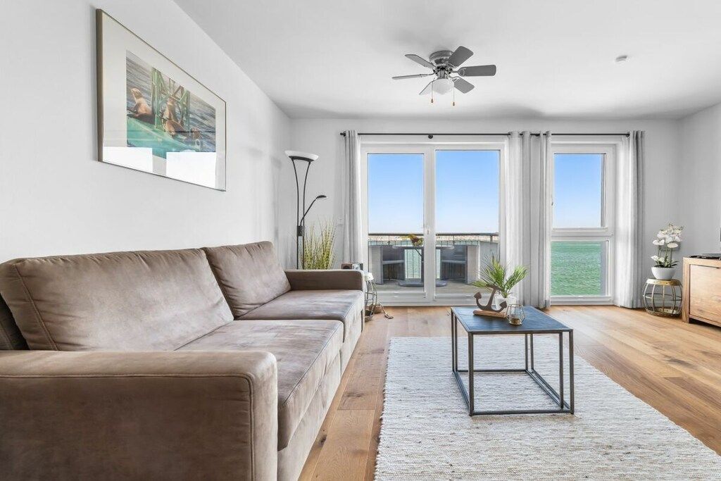 A living room with a sofa, a coffee table, and a ceiling fan.